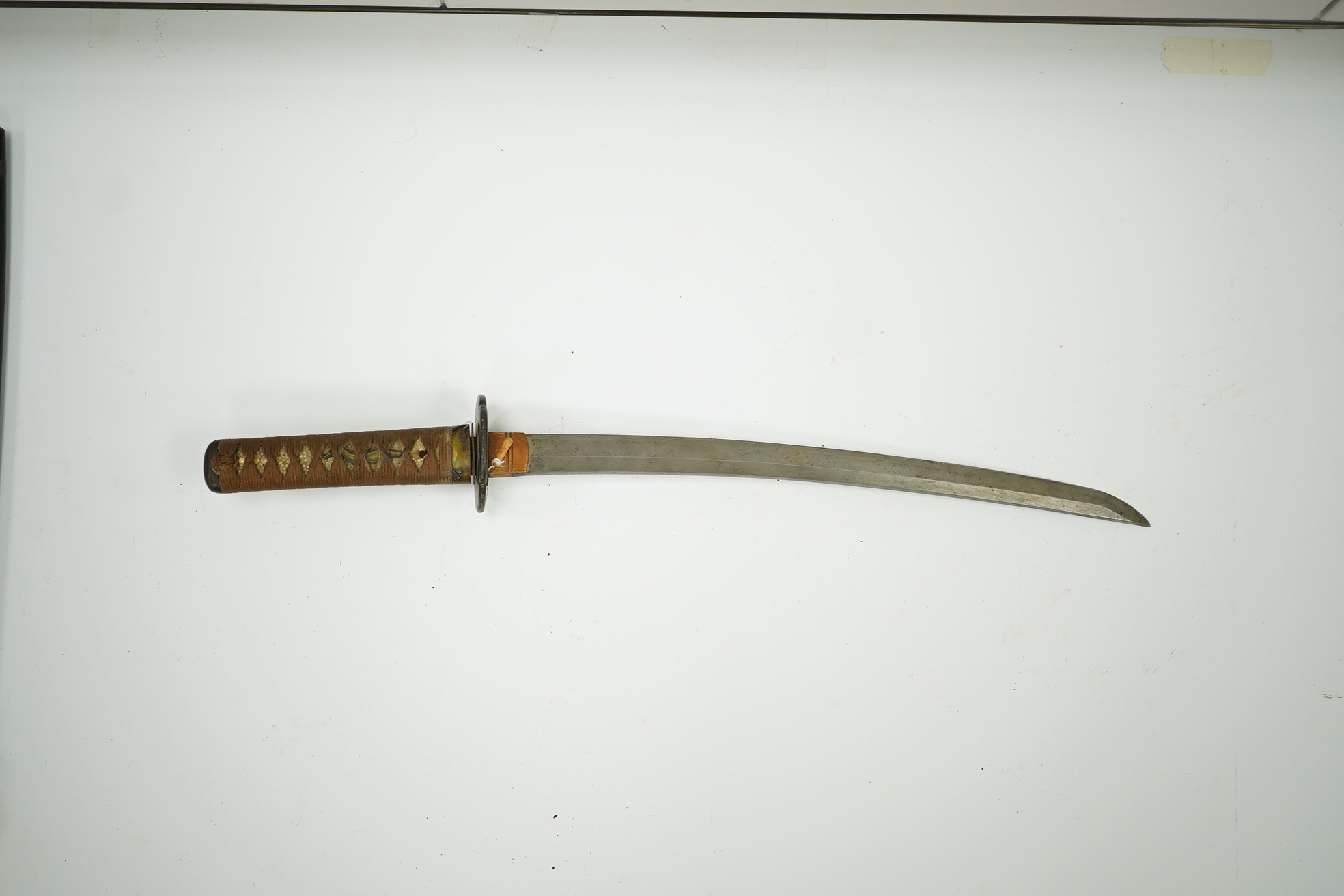 A 19th century Japanese sword wakizashi, blade 39.9cms, signed, iron Sukashi Tsuba of moko form, tape bound same tsuka with brass mounts, in its black lacquered saya. Condition - fair